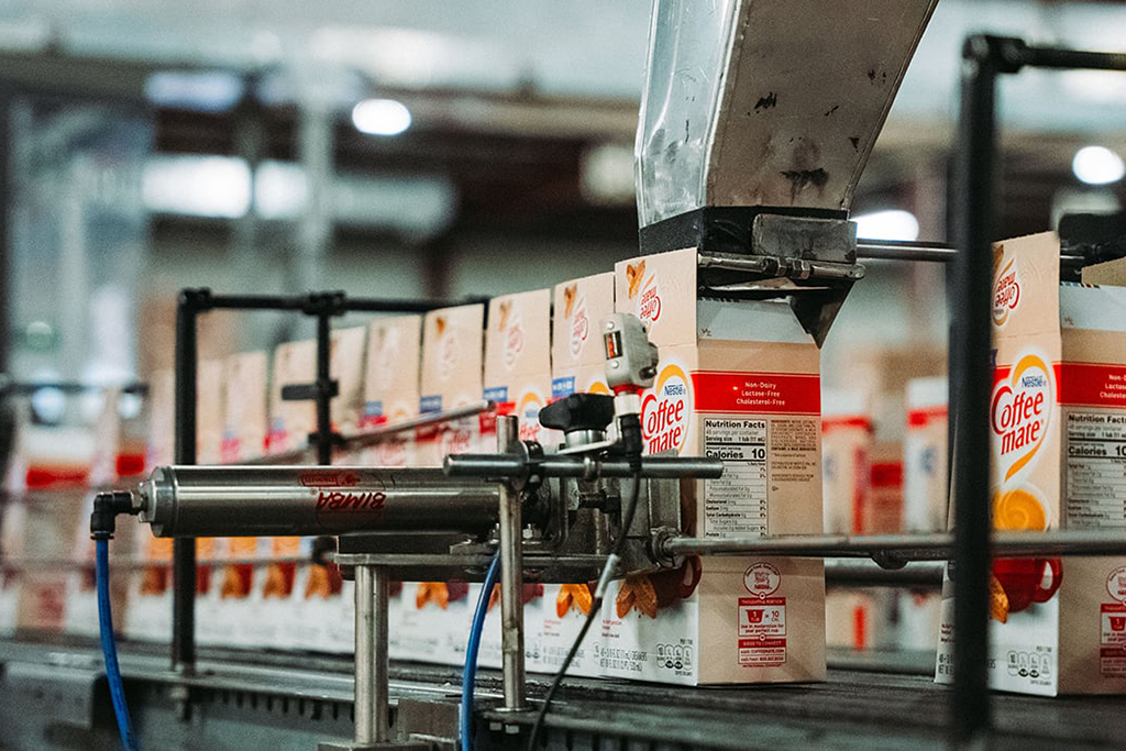 Creamer being packaged into Coffee Mate boxes